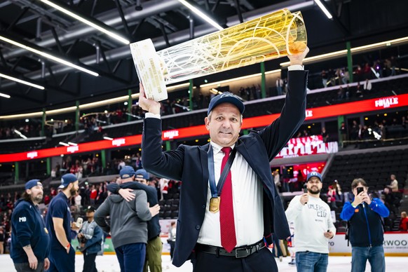 ARCHIV - ZSC Lions' Head coach Marco Bayer celebrates with the trophy of Swiss Champion after winning by 2:3 during the fifth leg of the National League Swiss Championship final playoff game betw ...