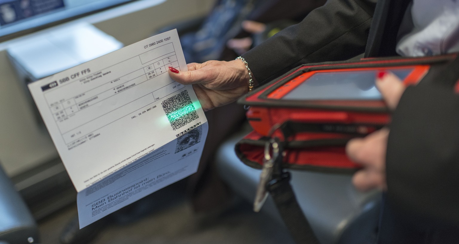 ARCHIV - Train attendant Priska Protmann of Swiss Federal Railways SBB scans a passenger&#039;s electronic ticket in the InterCity train from Zurich to Geneva, Switzerland, on May 29, 2013. --- Preisu ...