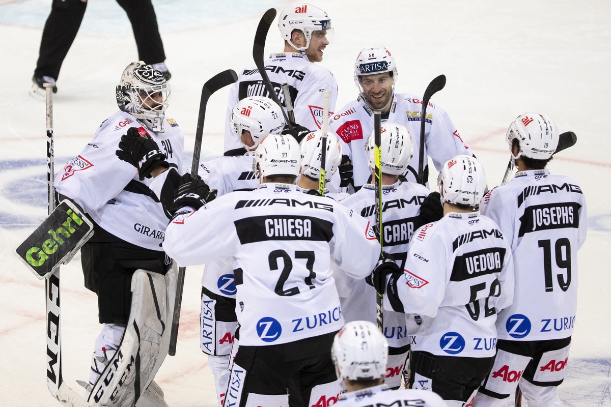 Luganos Torhueter Niklas Schlegel, links, und Luganos Romain Loeffel, hinten rechts, jubeln mit ihren Teamkollegen ueber den Sieg im Penaltyschiessen, im Eishockey Meisterschaftsspiel der National Lea ...
