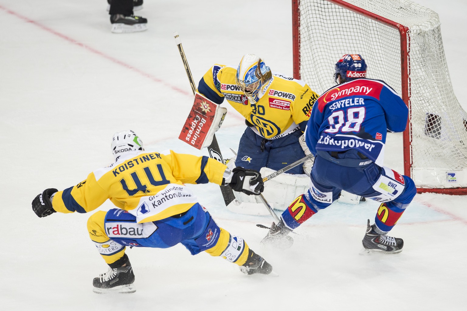 Sven Senteler vom ZSC, rechts, gegen Ville Koistinen, links, und Leonardo Genoni, Mitte, von Davos, beim Eishockey Meisterschaftsspiel der National League A zwischen den ZSC Lions und dem HC Davos am  ...