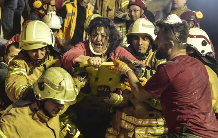 A woman reacts after rescue workers had pulled her out the rubble of an eight-story building which collapsed in Istanbul, Wednesday, Feb. 6, 2019. The eight-story building collapsed, killing at least  ...