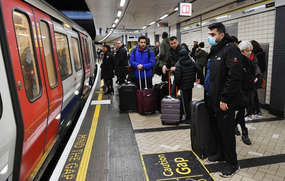 epa08267004 A man wearing a face mask waits to board an Underground train in London, Britain, 03 March 2020. Twelve more people have tested positive for Coronavirus in Britain bringing the total to 51 ...