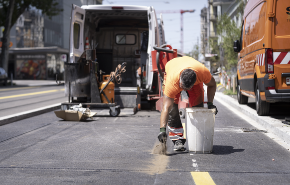 Bauarbeiter arbeiten bei grosser Hitze an der Sonne auf einer Baustelle an der Badenerstrasse, fotografiert am Mittwochnachmittag, 25. Juni 2025 in Zuerich. (KEYSTONE/Gaetan Bally)