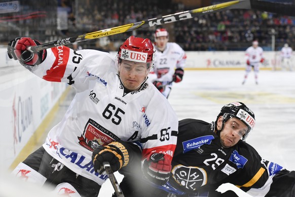 Lugano&#039;s Riccardo Sartori, right, fights for the puck against Mountfield&#039;s Rudolf Cerveny, left, during the game between HC Lugano and Mountfield HK at the 90th Spengler Cup ice hockey tourn ...
