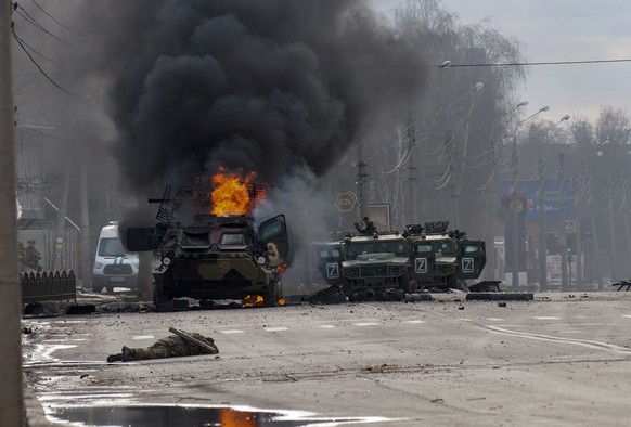 ADDS THAT THE PERSONNEL CARRIER IS RUSSIAN - A Russian armored personnel carrier burns amid damaged and abandoned light utility vehicles after fighting in Kharkiv, Ukraine, Sunday, Feb. 27, 2022. The  ...