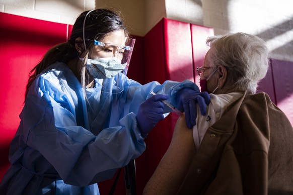 epa08939949 Millicent receives the Moderna vaccine against COVID 19 from nurse Hannah Fauni at the Corona High School amid the coronavirus pandemic in Corona, Riverside County, East of Los Angeles, Ca ...