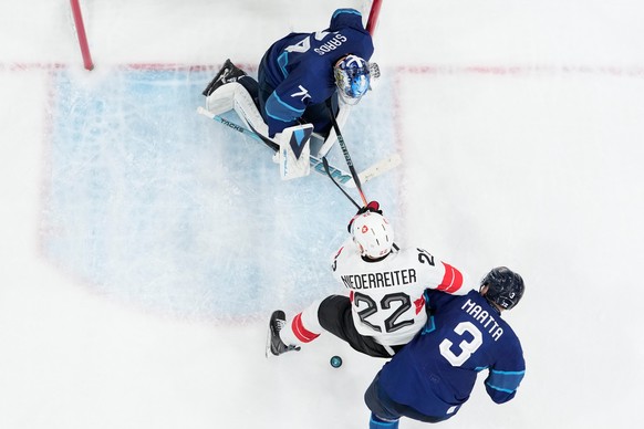Switzerland's Nino Niederreiter (22) is challenged by Olli Maatta (3) during a men's ice hockey quarterfinal game between Finland and Switzerland at the 2026 Winter Olympics, in Milan, Italy ...
