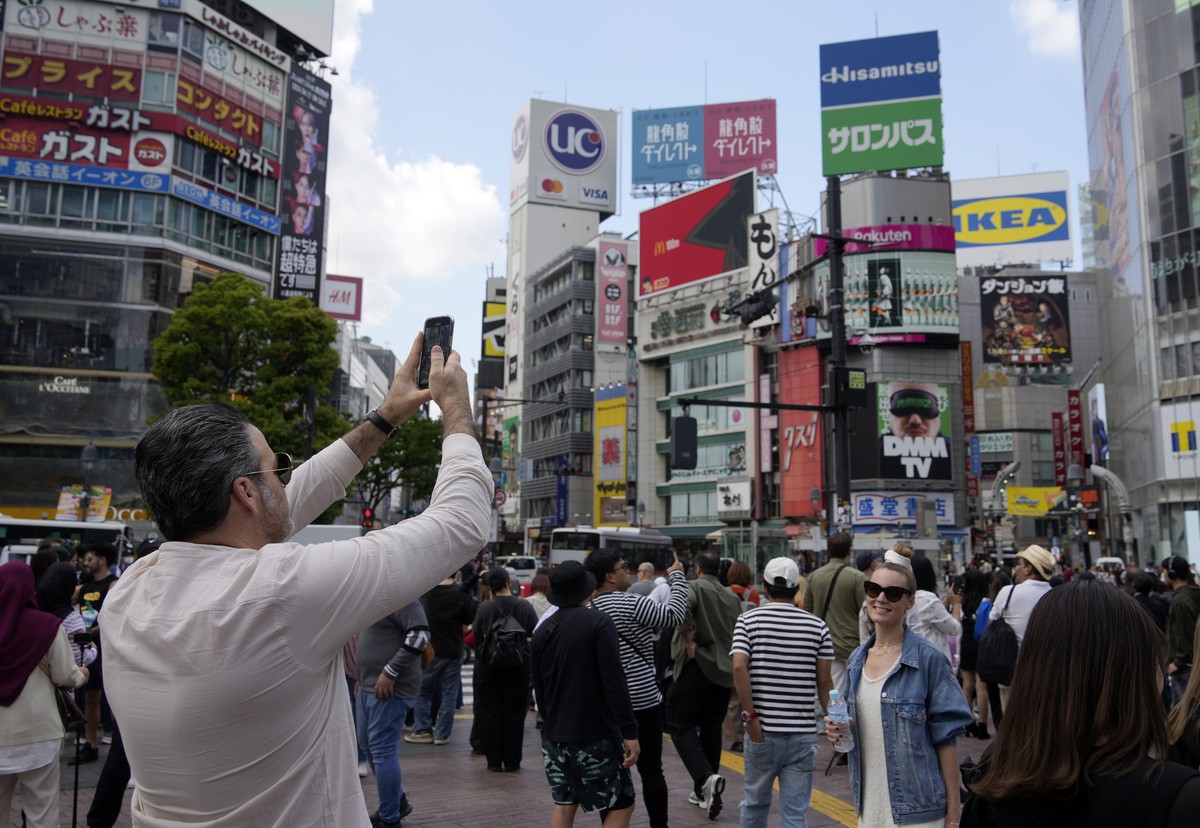 Le séisme n'a pas empêché les touristes de prendre des photos au carrefour de Shibuya à Tokyo, mercredi.