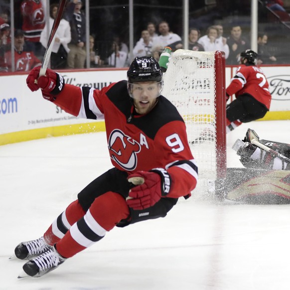 Ottawa Senators goaltender Craig Anderson right, watches as New Jersey Devils left wing Taylor Hall (9) celebrates after scoring a goal during the second period of an NHL hockey game, Friday, Dec. 21, ...