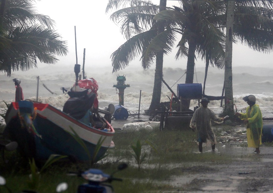 epa07260986 Thai villagers evacuate as high waves are seen in the background during heavy downpours caused by tropical storm Pabuk at a village in Pak Phanang district, Nakhon Si Thammarat province, s ...