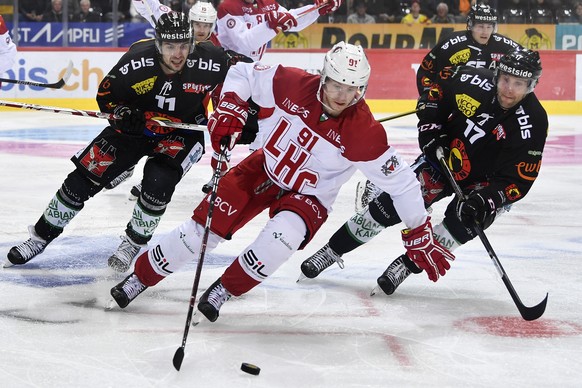 Berns Alain Berger, links, und Gian-Andrea Randegger, rechts, im Duell mit Lausannes Joel Vermin im Eishockey Meisterschaftsspiel der National League zwischen dem SC Bern und Lausanne HC, am Freitag,  ...