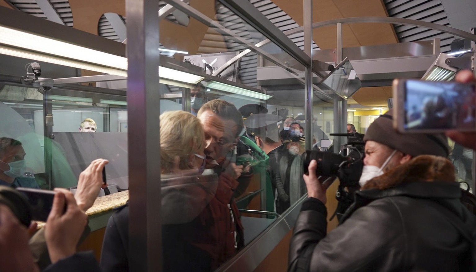 Alexei Navalny kisses his wife Yulia as he is detained by police at the passport control after arriving at Sheremetyevo, airport outside Moscow, Russia, Sunday, Jan. 17, 2021. Russia&#039;s prison ser ...