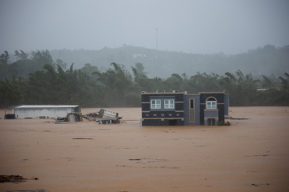 A home is submerged in floodwaters caused by Hurricane Fiona in Cayey, Puerto Rico, Sunday, Sept. 18, 2022. According to authorities three people were inside the home and were reported to have been re ...