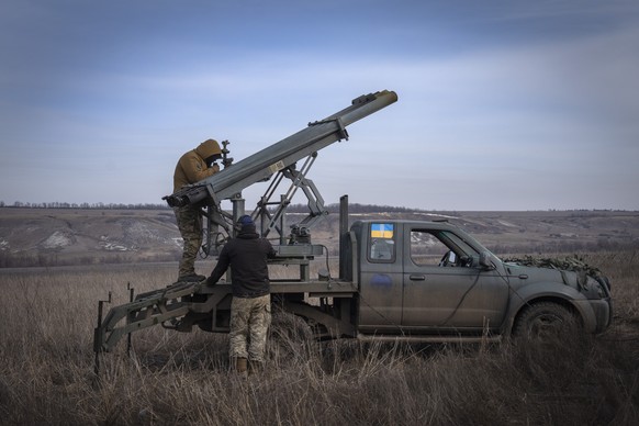 FILE - Ukrainian soldiers of the 56th Separate Motorized Infantry Mariupol Brigade prepare to fire a multiple rocket system, based on a pick-up truck, towards Russian positions on the front line...