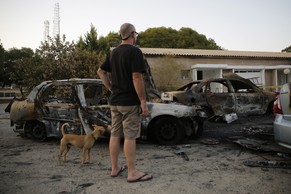 Ein Mann betrachtet durch Mörsergranaten zerstörte Autos bei einem Kibbuz in Nahal Oz an der Grenze zu Gaza.