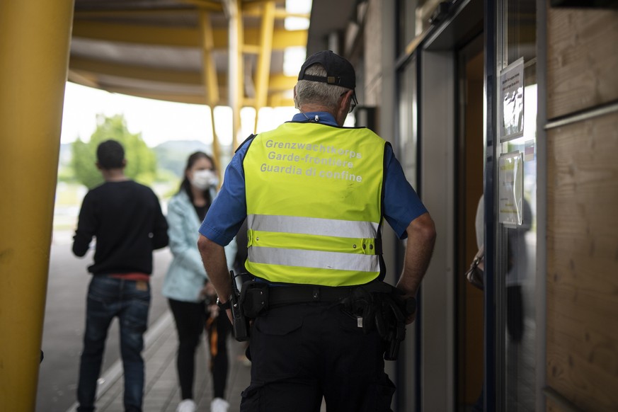 Ein Grenzwaechter am Autobahn-Zoll kontrolliert die Einhaltung des Abstandes von Menschen, die zur Ruckerstaettung der Mehrwertsteuer anstehen, aufgenommen am Montag, 15. Juni 2020, in Kreuzlingen. Di ...