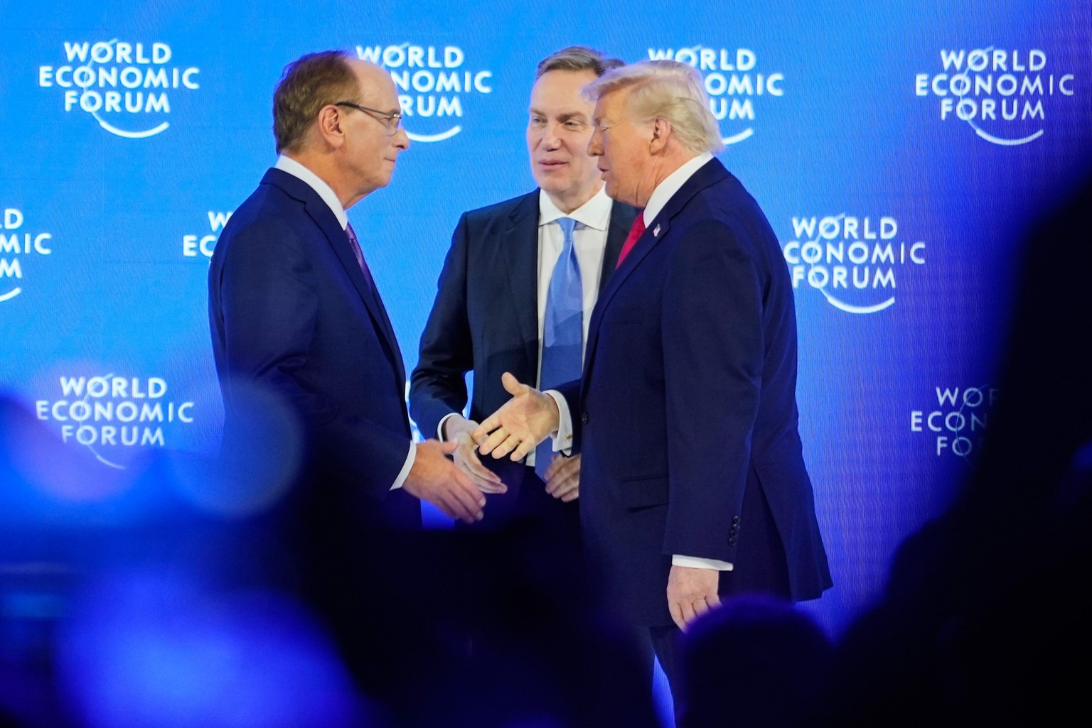 President Donald Trump is welcomed by Forum's President Borge Brende and Forum's Co-Chair Larry Fink on the podium before his speech during the Annual Meeting of the World Economic Forum in  ...