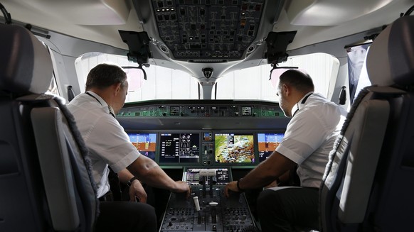 epa05410757 Two men sit in the cockpit of a new Bombardier C-Series CS100 airplane of the airline SWISS as it is presented on the occasion of the aircraft's baptism at the Zurich Airport in Klote ...