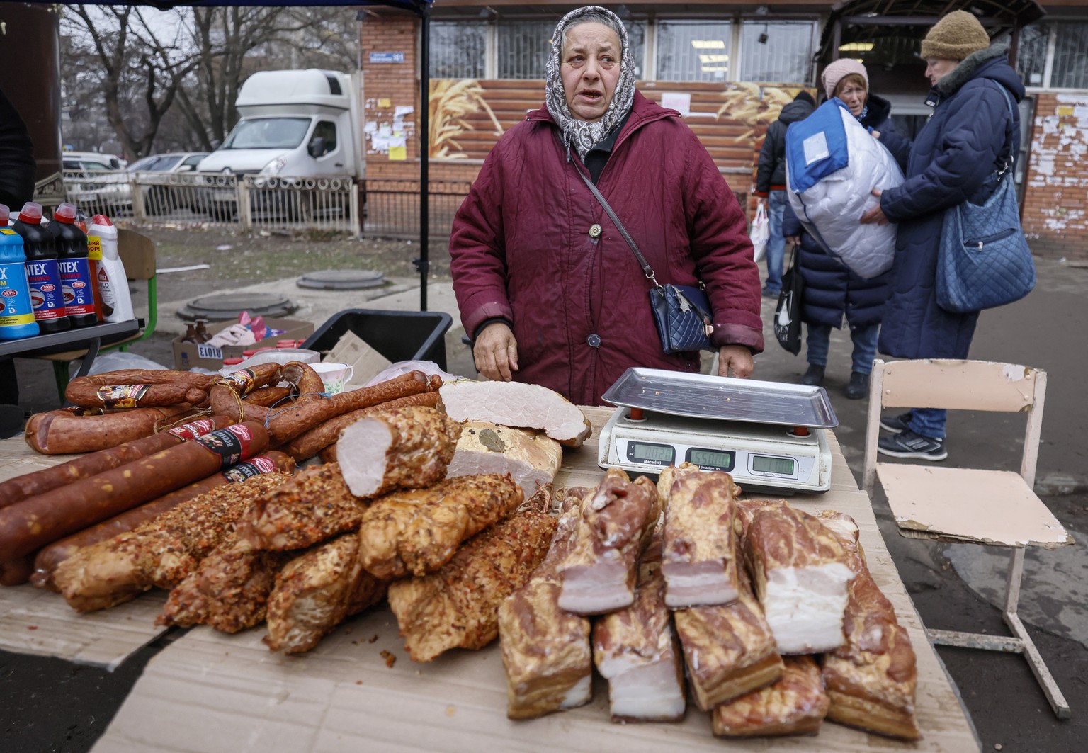 epa10360655 Local residents gather at an outdoor market in Mariupoll, Ukraine, 10 December 2022 (issued 11 December 2022). An estimate 250,000 inhabitants have left the city, about 300,000 still remai ...