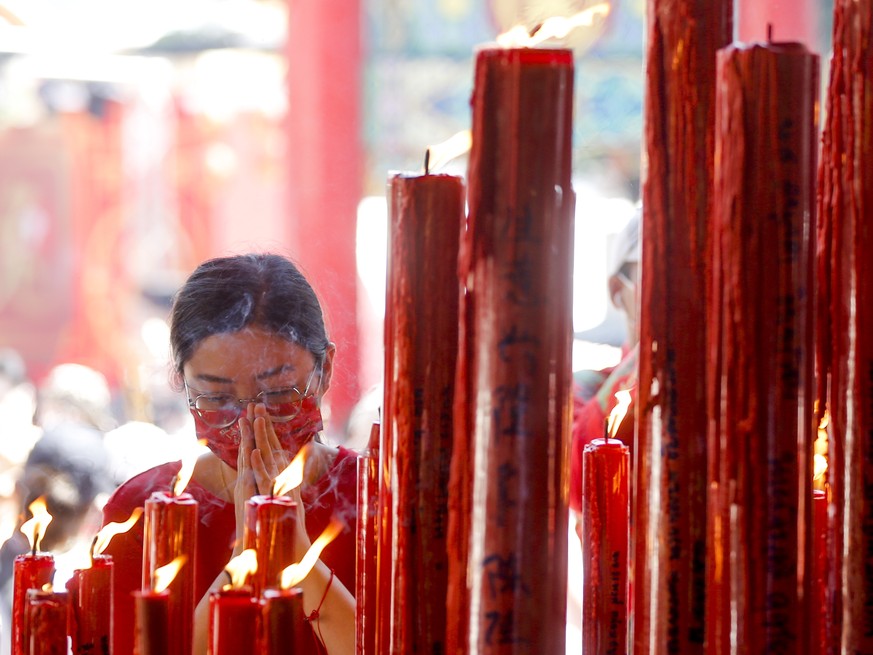 epa10422205 A woman prays to welcome the Chinese Lunar New Year at a Chinese Buddhist temple in Chinatown, Bangkok, Thailand, 22 January 2023. The Chinese lunar new year, or Spring Festival as it is k ...