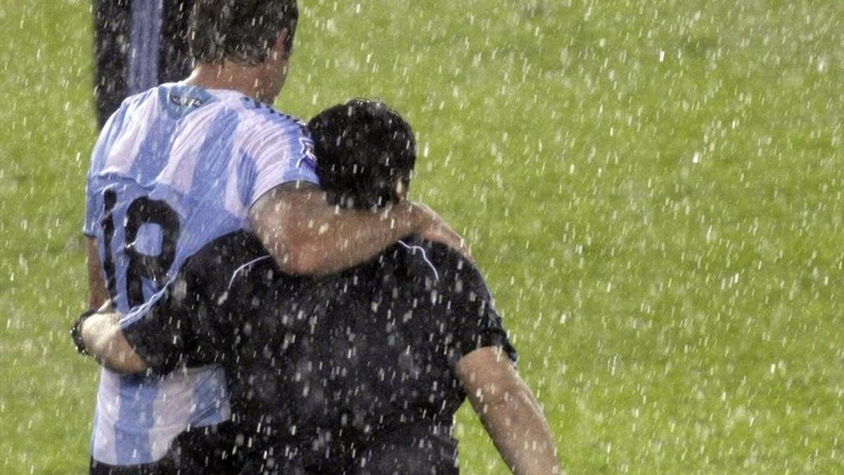 Under pouring rain, Argentina's Martin Palermo, left, and Argentina's coach Diego Maradona leave the field at the end of a 2010 World Cup qualifying soccer match against Peru in Buenos Aires ...