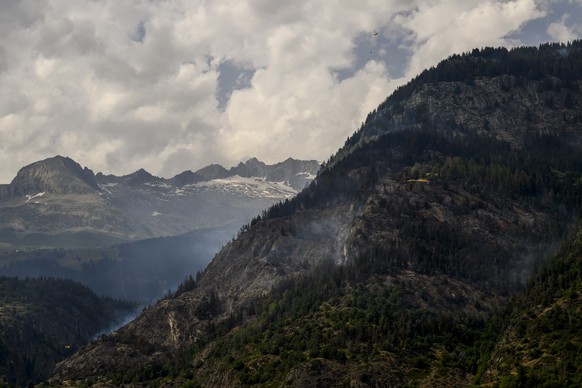 Un helicoptere Super Puma verse de l&#039;eau sur la fumee qui s&#039;echappe de la foret en feu au dessus des communes de Bitsch et Ried-Moerel le mardi 18 juillet 2023 depuis Termen. Les h駘icopteres ...