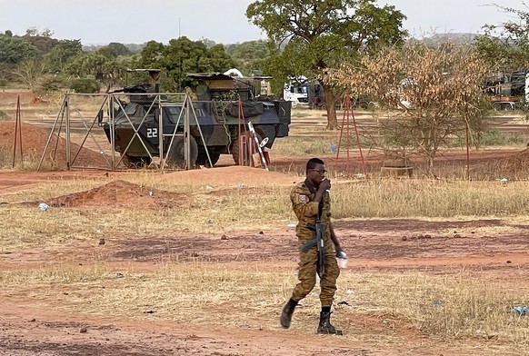 A Burkinabe soldier walks past a French Armoured Personnel Carrier part of a French military convoy heading to Niger, stopped by protesters in Kaya, Burkina Faso, Saturday Nov. 20, 2021. Residents of  ...