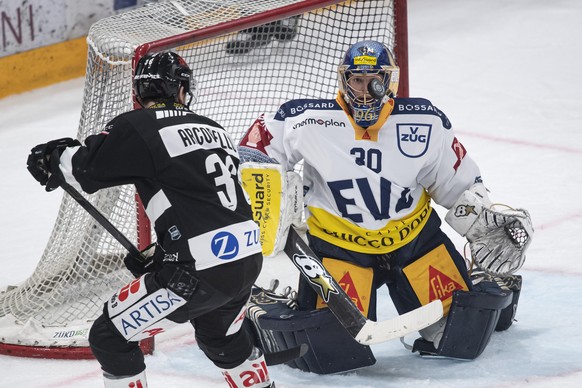 From left, Lugano&#039;s player Mark Arcobello and Zug&#039;s goalkeeper Leonardo Genoni during the second game of the quarter final playoffs of the National League 2021/22 between HC Lugano against E ...