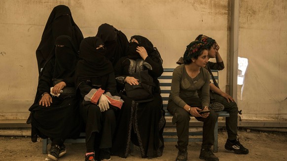 Kurdische YPJ-Kämpferinnen bewachen IS-Frauen.