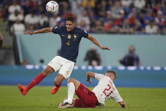 France&#039;s Raphael Varane, left, challenges for the ball with Denmark&#039;s Andreas Cornelius during the World Cup group D soccer match between France and Denmark, at the Stadium 974 in Doha, Qata ...