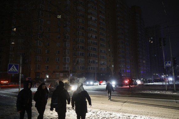 epa12647163 People walk with flashlights on the dark street during an electricity cut-off in Kyiv, Ukraine, 13 January 2026, amid the ongoing Russian invasion. The Ukrainian capital is faced with hard ...