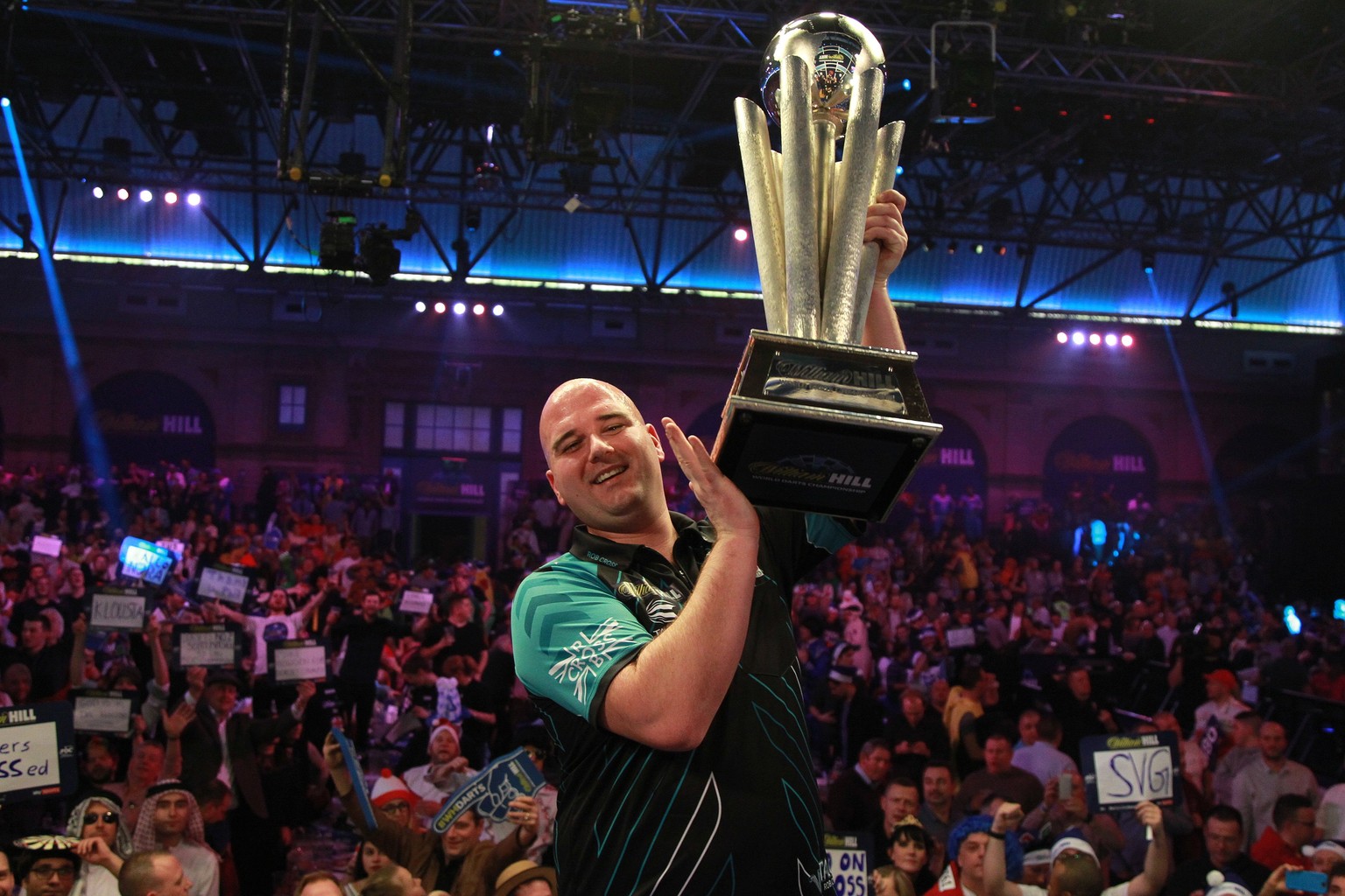 epa06413097 Rob Cross of England hoists the trophy after winning the PDC World darts final match over Phil Taylor of England at the Alexander Palace in North London, Britain, 01 January 2018. Phil Tay ...