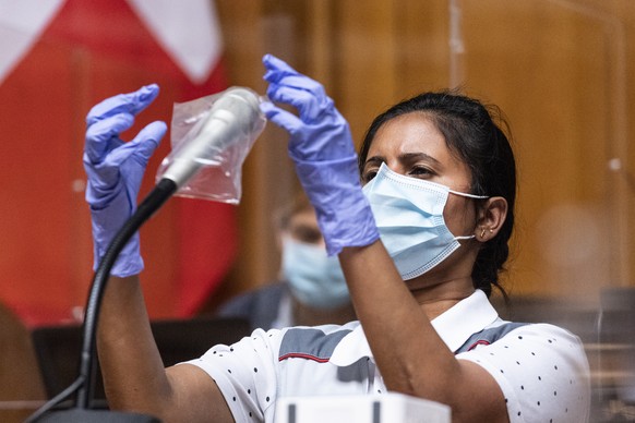 Mathivathany Gunasingam, Mitarbeiterin Reinigung des Bundesamtes fuer Bauten und Logistik (BBL), desinfiziert ein Rednerpult und ersetzt die Plastikueberzuege, am ersten Tag der Herbstsession der Eidg ...