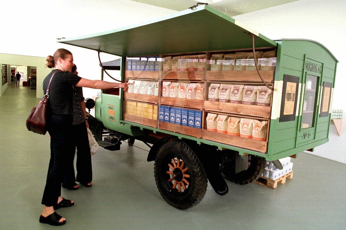 Zwei Besucherinnen betrachten an der Ausstellung "Das soziale Kapital" den ersten Verkaufswagen der Migros, ein Ford mit Jahrgang 1925, im Migros-Museum in Zuerich am 22. August 1998. Es ist ...