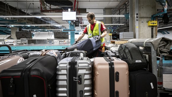 Ein Gepaecksortierer von Swissport arbeitet in der Gepaecksortierung am Flughafen Zuerich am Dienstag, 12. Juli 2022. (KEYSTONE/Alexandra Wey)