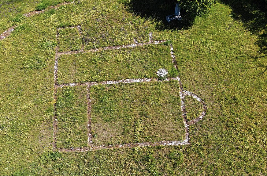 Luftbild der ehemaligen Kirche. Der Steinhaufen rechts ist die Feuerstelle, oben im Schatten ein kleines Denkmal und die Sitzbank.