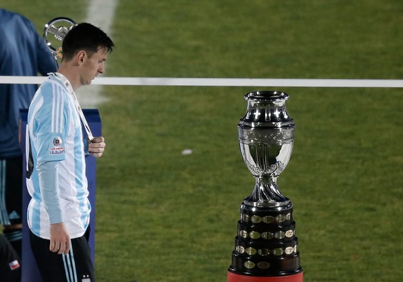 Argentina&#039;s Lionel Messi walks next to the Copa America trophy during the Copa America final soccer match at the National Stadium in Santiago, Chile, Saturday, July 4, 2015. (AP Photo/Silvia Izqu ...