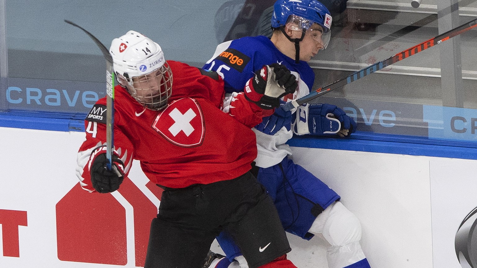 Switzerland&#039;s Lorenzo Canonica (14) checks Slovakia&#039;s Marko Stacha (16) during the first period at IIHF world junior hockey tournament in Edmonton, Alberta, Friday, Dec. 25, 2020. (Jason Fra ...