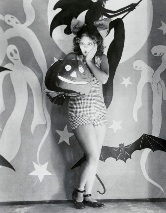 1929 (Original Caption) Clara Bow, celebrated movie star as she looks in costume holding a Halloween pumpkin. Miss Bow sure makes a pretty picture, in this outfit, and one that most anybody would be p ...