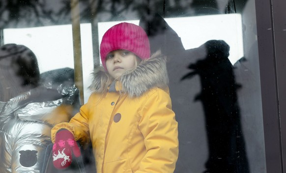 epa09806524 A Ukrainian refugee girl looks trough the window of her transit bus shortly after passing trough the Romanian-Ukrainian border crossing point in Siret, northern Romania, 06 March 2022. Rus ...