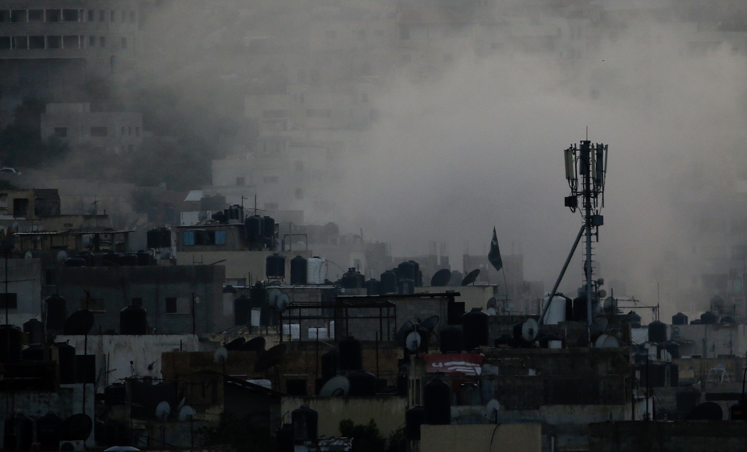 epa10726687 Smoke rises over the Jenin refugee camp on the second day of an Israeli military operation, in West Bank, 04 July 2023. The Israeli army stated on 03 July that they launched a large-scale  ...