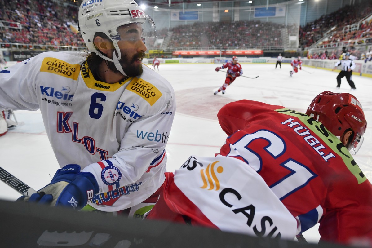 Klotens Tim Ramholt, links, gegen Michael Huegli von Rapperswil im vierten Eishockey Spiel der Ligaqualifikation der National League zwischen den SC Rapperswil-Jona Lakers und dem EHC Kloten am Donner ...