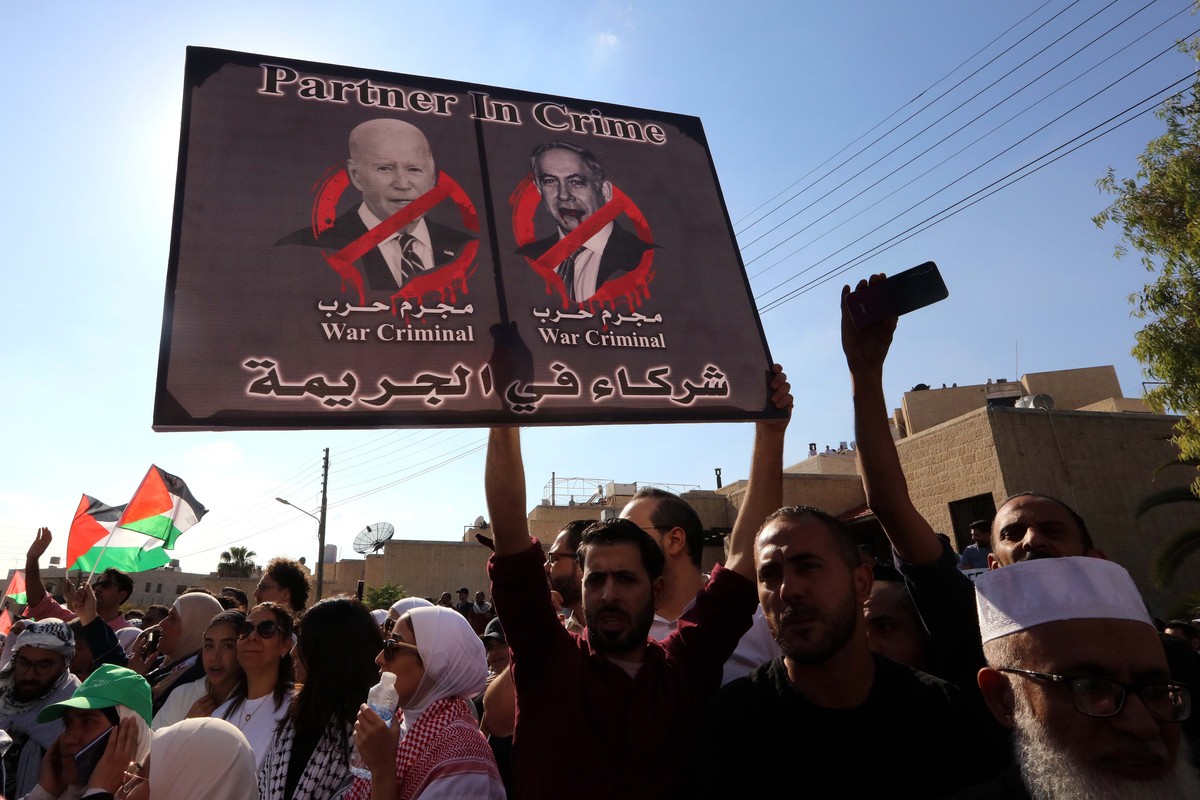 epa10925639 A protester holds up a placard depicting US President Joe Biden (L) and Israeli Prime Minister Benjamin Netanyahu during a pro-Palestinian rally near the Israeli embassy following a strike ...