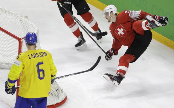 Switzerland&#039;s Dean Kukan, right, falls during the Ice Hockey World Championships final match between Sweden and Switzerland at the Royal arena in Copenhagen, Denmark, Sunday, May 20, 2018. (AP Ph ...