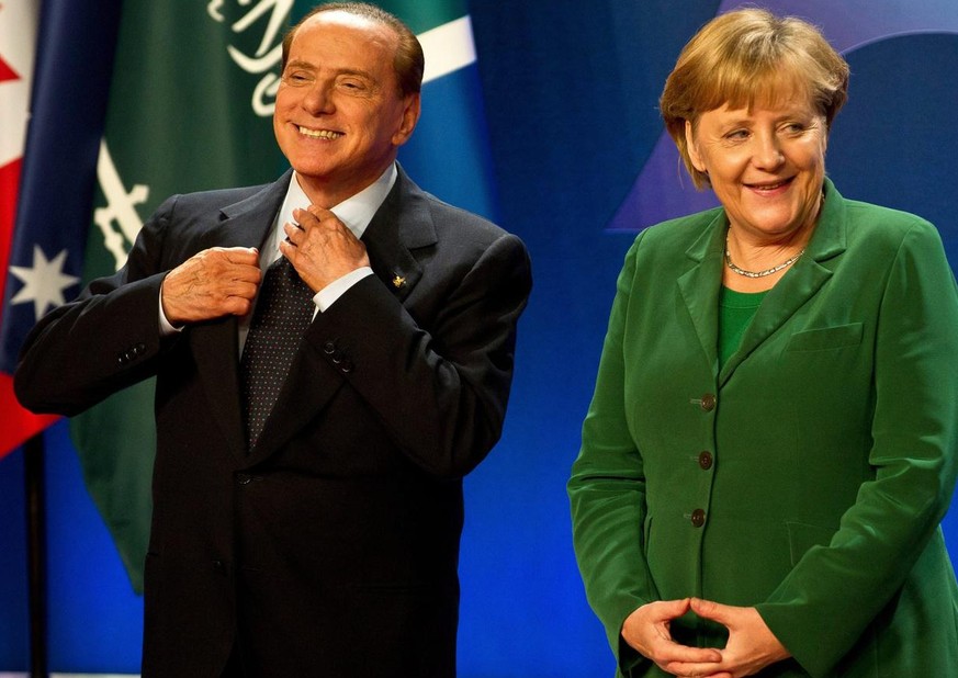 epa02991028 German Chancellor Angela Merkel (R) and Italian President Silvio Berlusconi wait for the group picture at the G20 summit in Cannes, France, 03 November 2011. The G20 leaders are in Cannes  ...