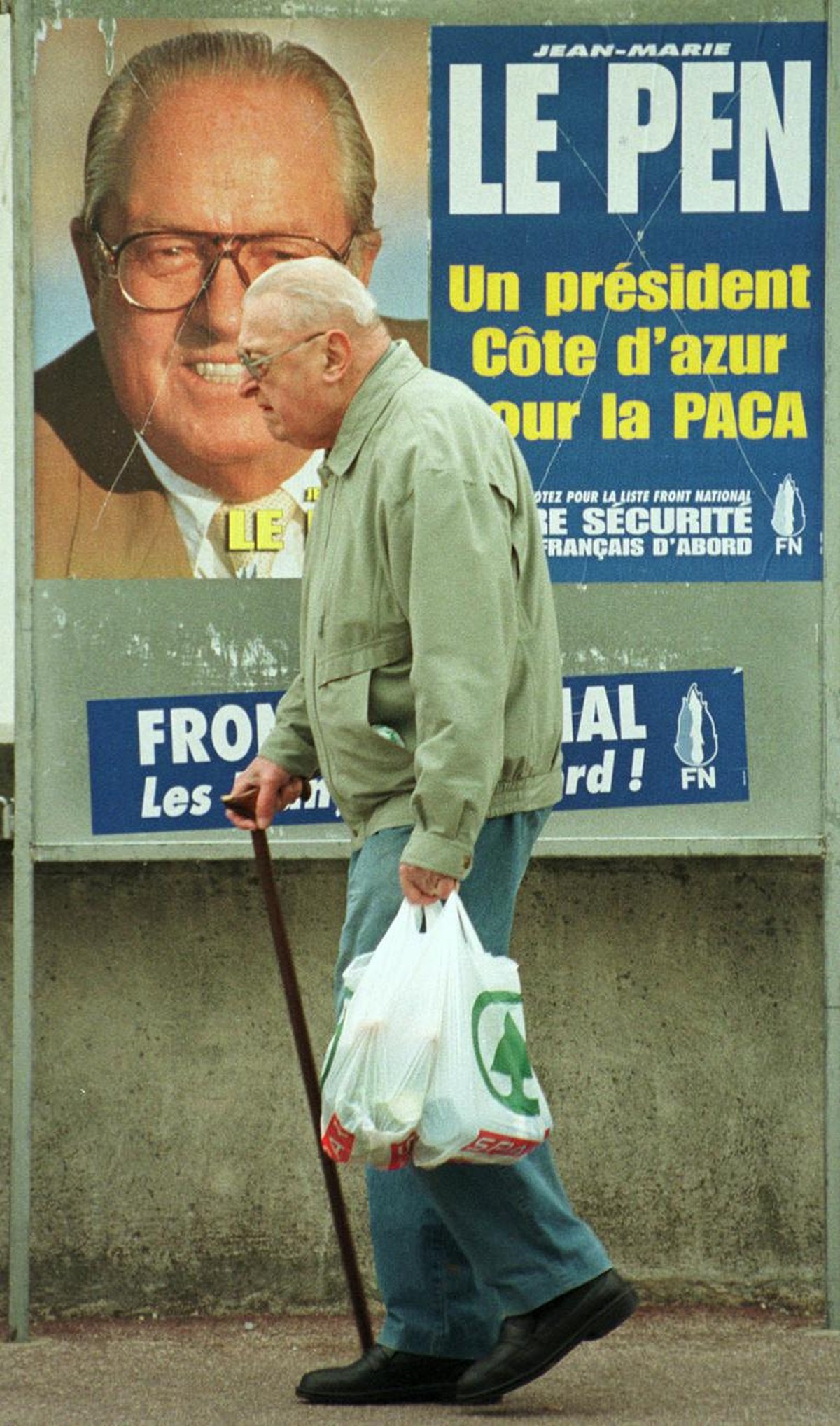 An old man walks past an election poster for the far right national front leader Jean-Marie Le Pen, Wednesday March 11, 1998, in Nice on the French riviera. Le Pen is running in Sunday's regional ...