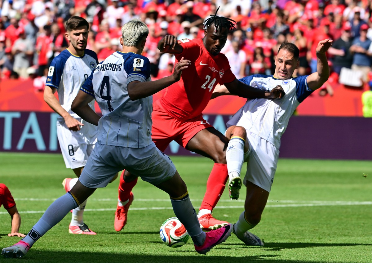 epaselect epa13033520 Promise David of Canada (C) and Tarik Muharemovic of Bosnia and Herzegovina (front) in action during the FIFA World Cup 2026 group stage match Canada against Bosnia and Herzegovi ...