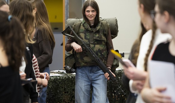 Eine junge Frau probiert eine 39 Kilogramm schwere Ausruestung an, beim Orientierungstag zum Militaerdienst exklusiv fuer Frauen, am Samstag, 15. Maerz 2025, in der Mannschaftskaserne der Schweizer Ar ...