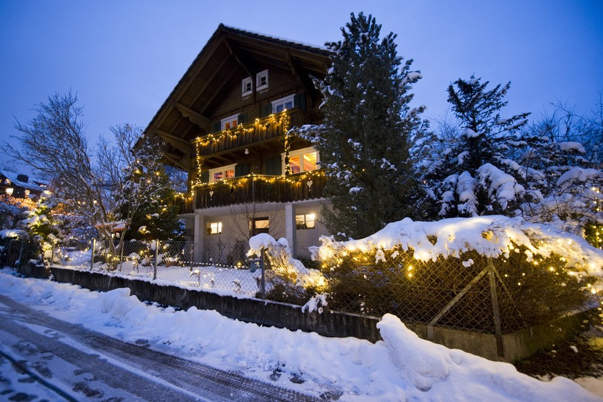 Ein Chalet in Meggen ist am Montag, 3. Dezember 2012 weihnachtlich geschmueckt. Der Schnee verstaerkt den Lichtzauber der Girlanden in Garten und Haus. (KEYSTONE/Sigi Tischler)