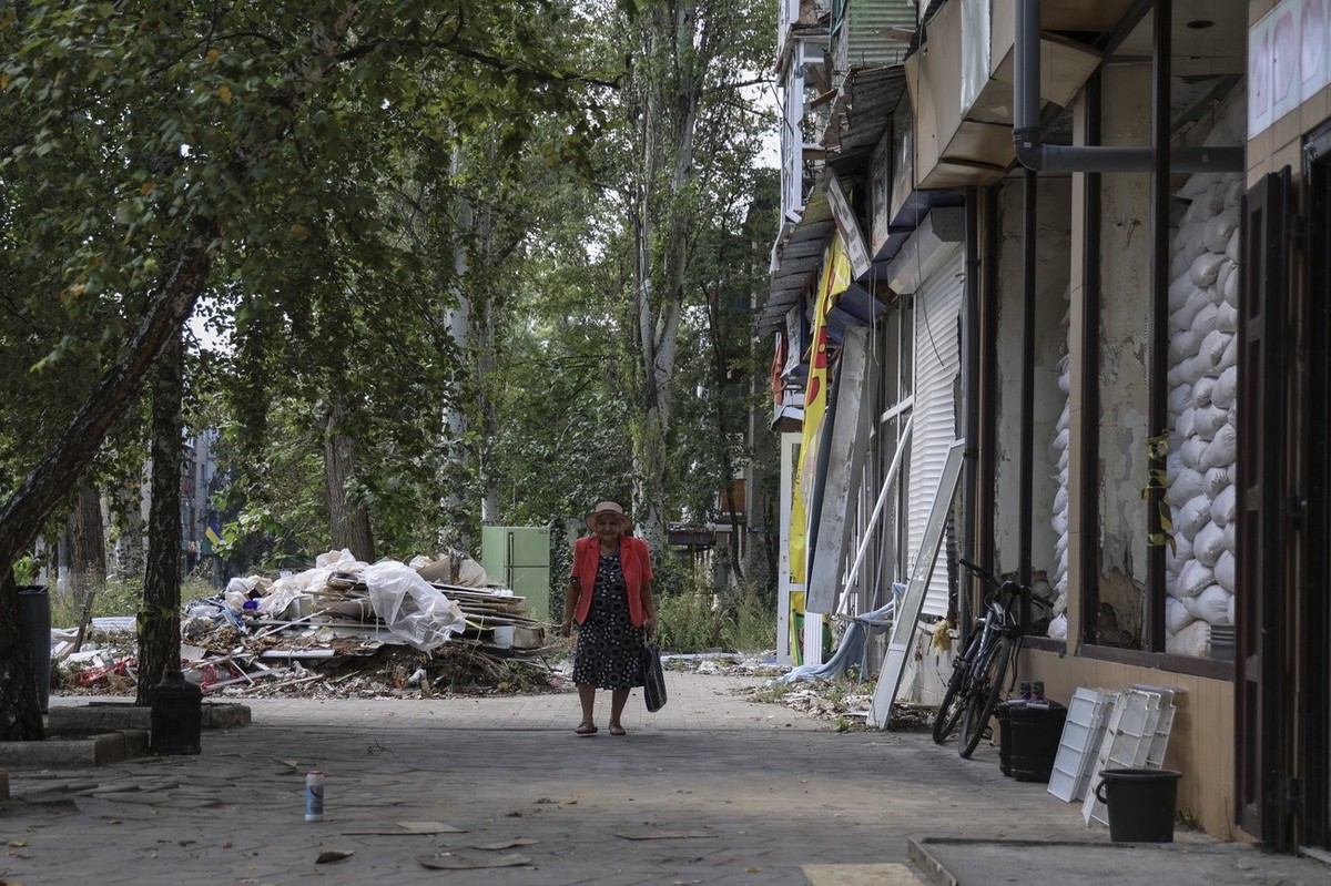 epa10825908 A local woman walks on a shelled street in Avdiivka settlement near a frontline in Donetsk region, Ukraine, 28 August 2023, amid Russia's ongoing invasion. About 1,600 locals still li ...